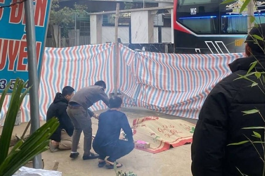 Nam thanh nien sang duong, bi xe khach dam tu vong ngay truoc nha hinh anh