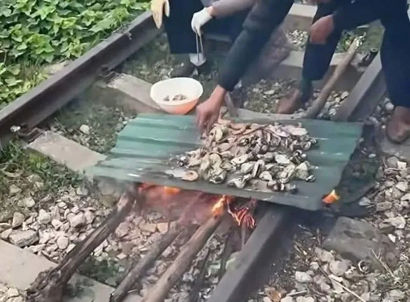 Xu phat cap vo chong ngoi tren duong ray tau nuong do an hinh anh