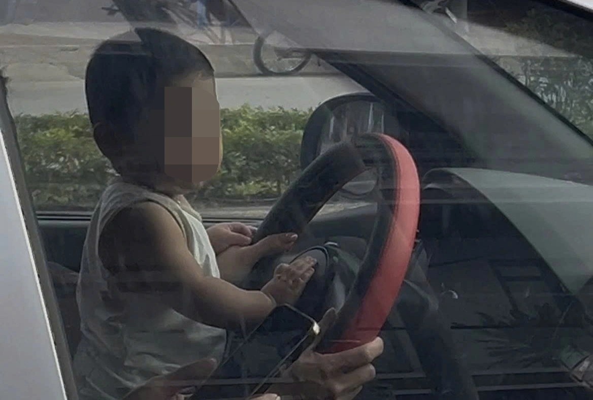 Nu tai xe de tre nho cam vo lang khi xe dang chay hinh anh