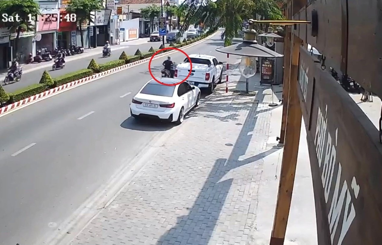 Nguoi dan ong chay xe may dap guong chieu hau oto tren pho hinh anh