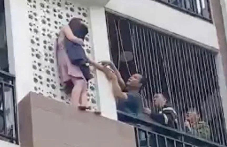 Cuu co gai treo ra ngoai tang cao ngoi nha hinh anh