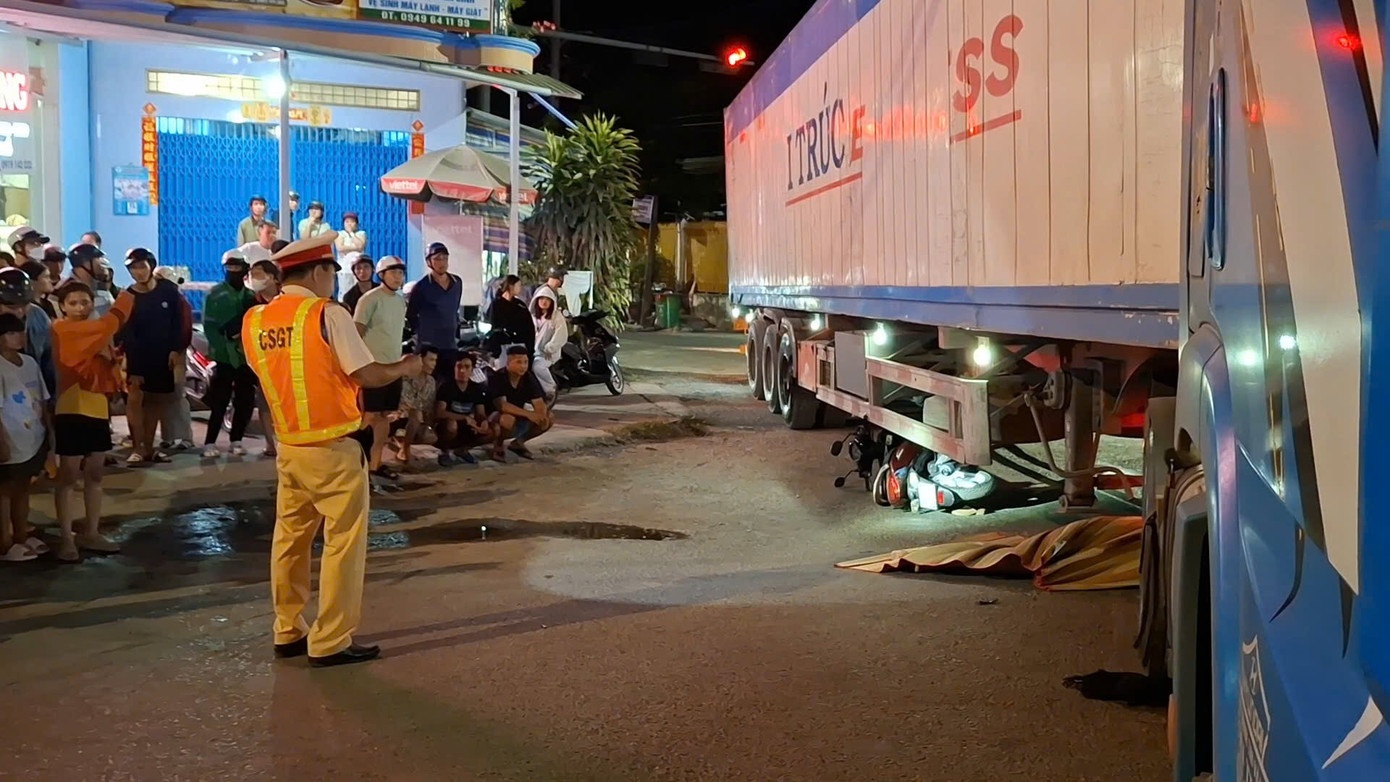 Xe may bi cuon gam xe container, 2 nguoi thuong vong hinh anh