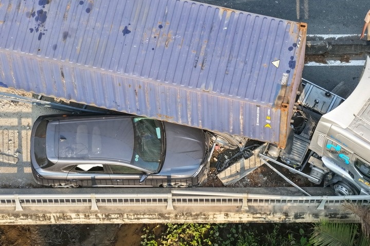 Xe container va cham oto 7 cho, cua ngo TP.HCM un tac keo dai hinh anh