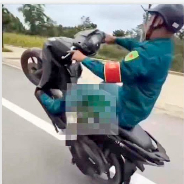 Thanh nien mac trang phuc dan quan tu ve boc dau xe may hinh anh