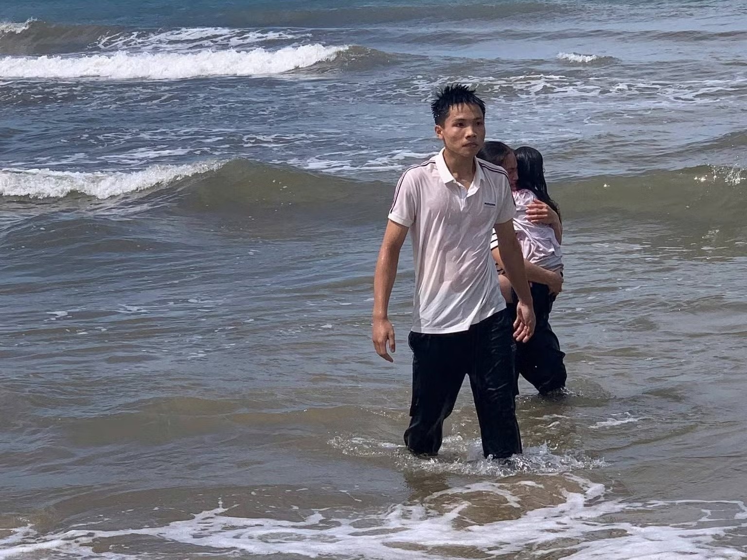 Nam sinh dung cam lao ra bien cuu em nho duoi nuoc hinh anh