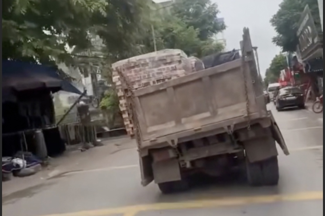Xe tải không biển số phía sau, chở hàng lệch một bên