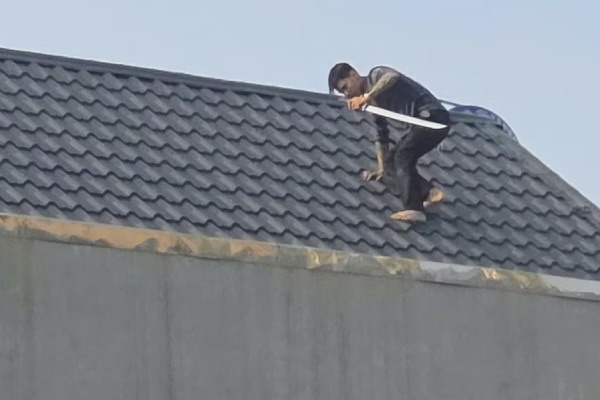 Vây bắt 2 người cầm hung khí cố thủ trên mái nhà