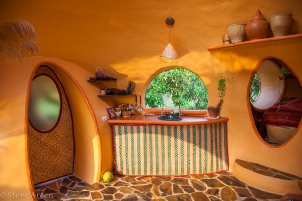 Nhà tắm nối với phòng bếp bằng cánh cửa nan tre có kính mờ.