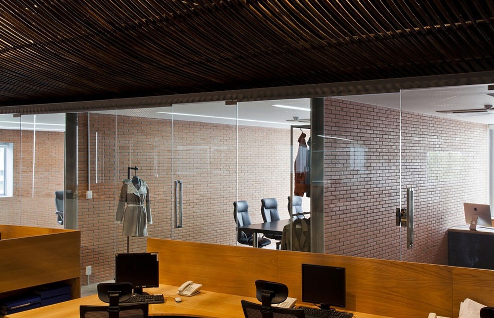 Các phòng riêng hoặc phòng họp được ngăn cách bằng tường gạch trần, với một mặt kính lấy sáng tự nhiên.