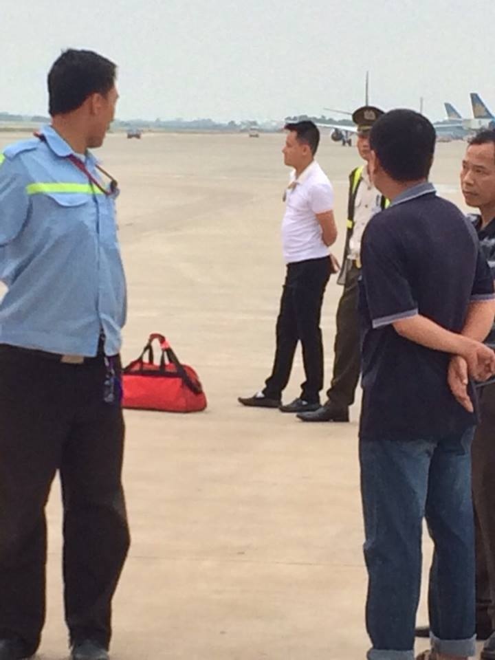 Nam hành khách (áo trắng) bị khống chế cùng hành lý xách tay nghi có bom.