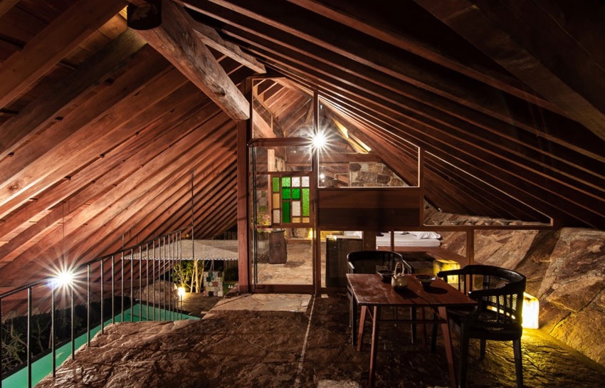 Tầng trên được chia thành hai không gian nhỏ, gồm phòng ngủ và bàn nước, được phân tách bằng cửa kính màu khung gỗ.