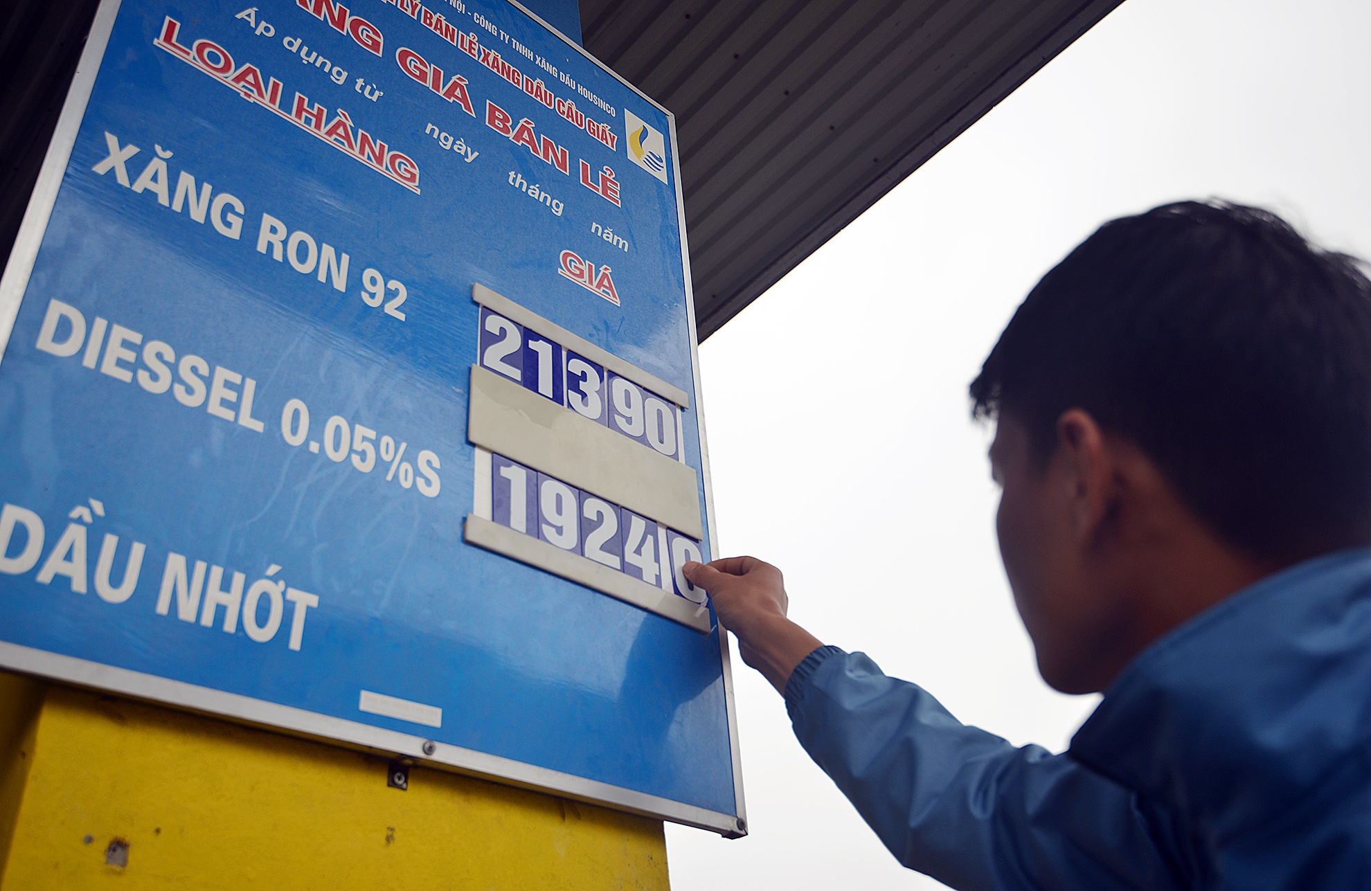 Nhân viên cửa hàng xăng dầu trên phố Dương Đình Nghệ (Hà Nội) thay bảng giá lúc 11h20 trưa nay. Ảnh: Lê Hiếu.