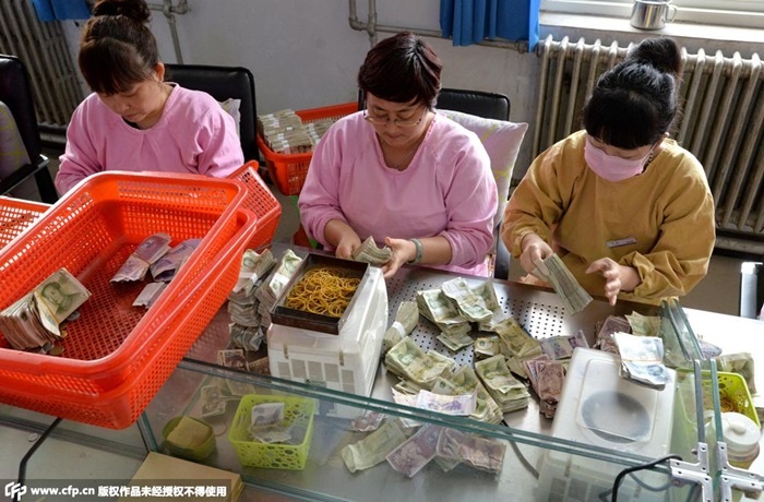 Các nhân viên ngồi cần mẫn đếm, phân loại các tờ tiền được từng xe nộp về trụ sở chính. 