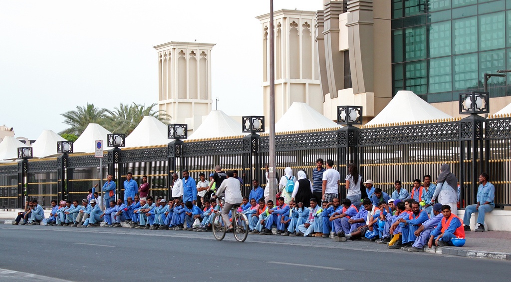 Nhóm công nhân chờ xe buýt để về khu vực sống, bỏ lại phía sau thành phố Dubai hoa lệ trong mắt khách du lịch. Ảnhh: Flickr.