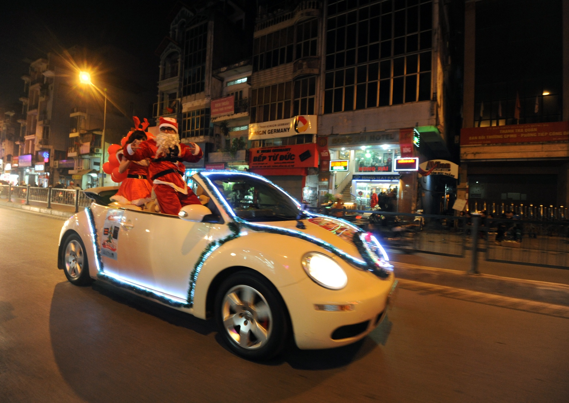 Không giống như hình thức phát quà Noel bằng xe máy của ông già Noel mà mỗi dịp giáng sinh tới, xuất hiện trên đường phố Hà Nội đêm 23-12 hình ảnh chiếc xe mui trần 2 cửa phi trên đường không khỏi làm nhiều tò mò.