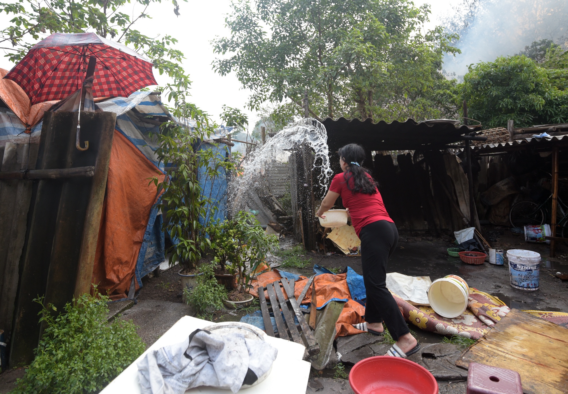 Nhiều hộ dân sống xung quan khu vực xảy ra cháy phải hất nước vào mái nhà để ngăn đám cháy lan vào nhà mình.