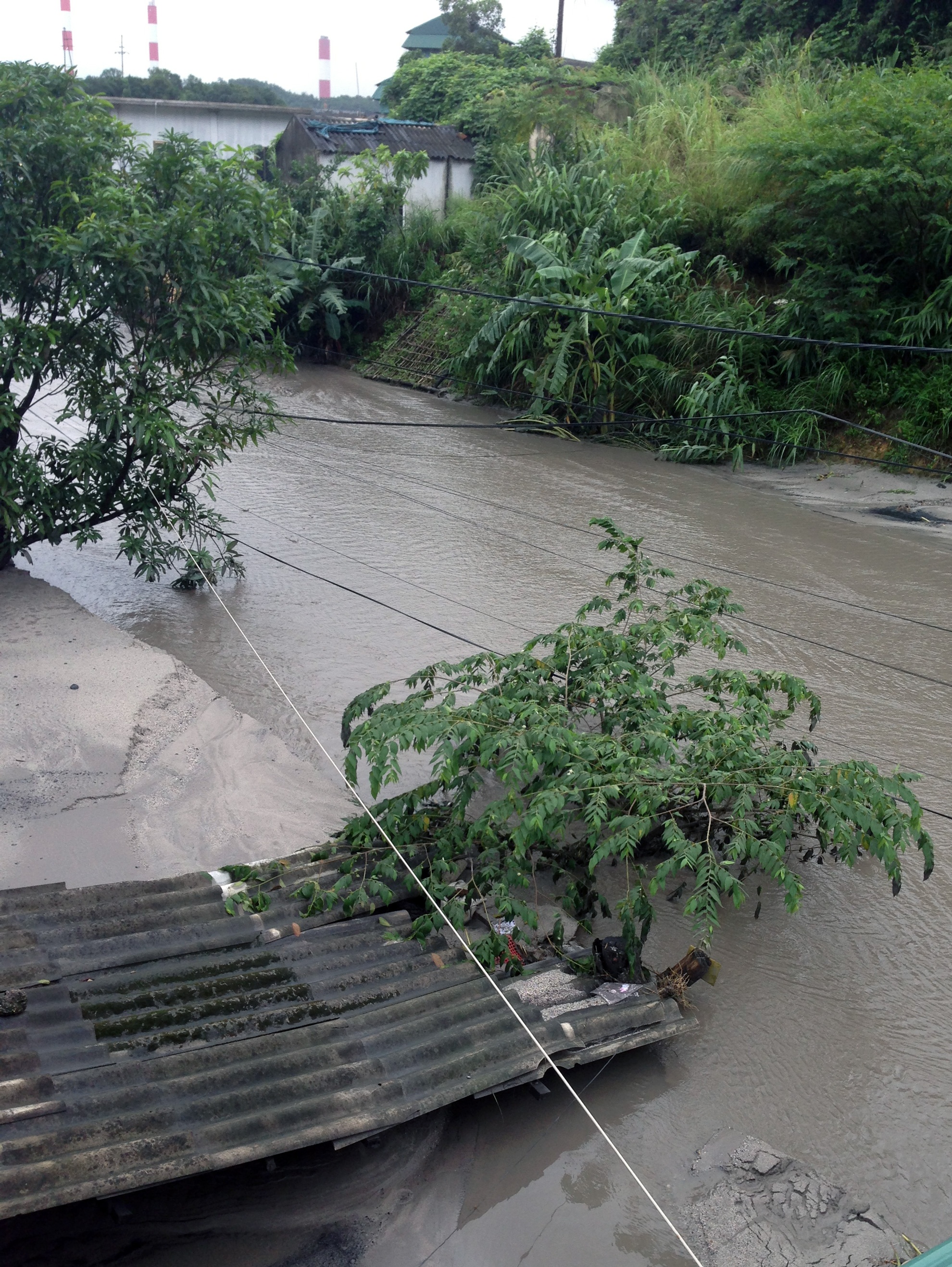 Trưa 30/7, nhiều người dân bất chấp nguy hiểm leo qua các nóc nhà để vào kiểm tra đồ đạc.