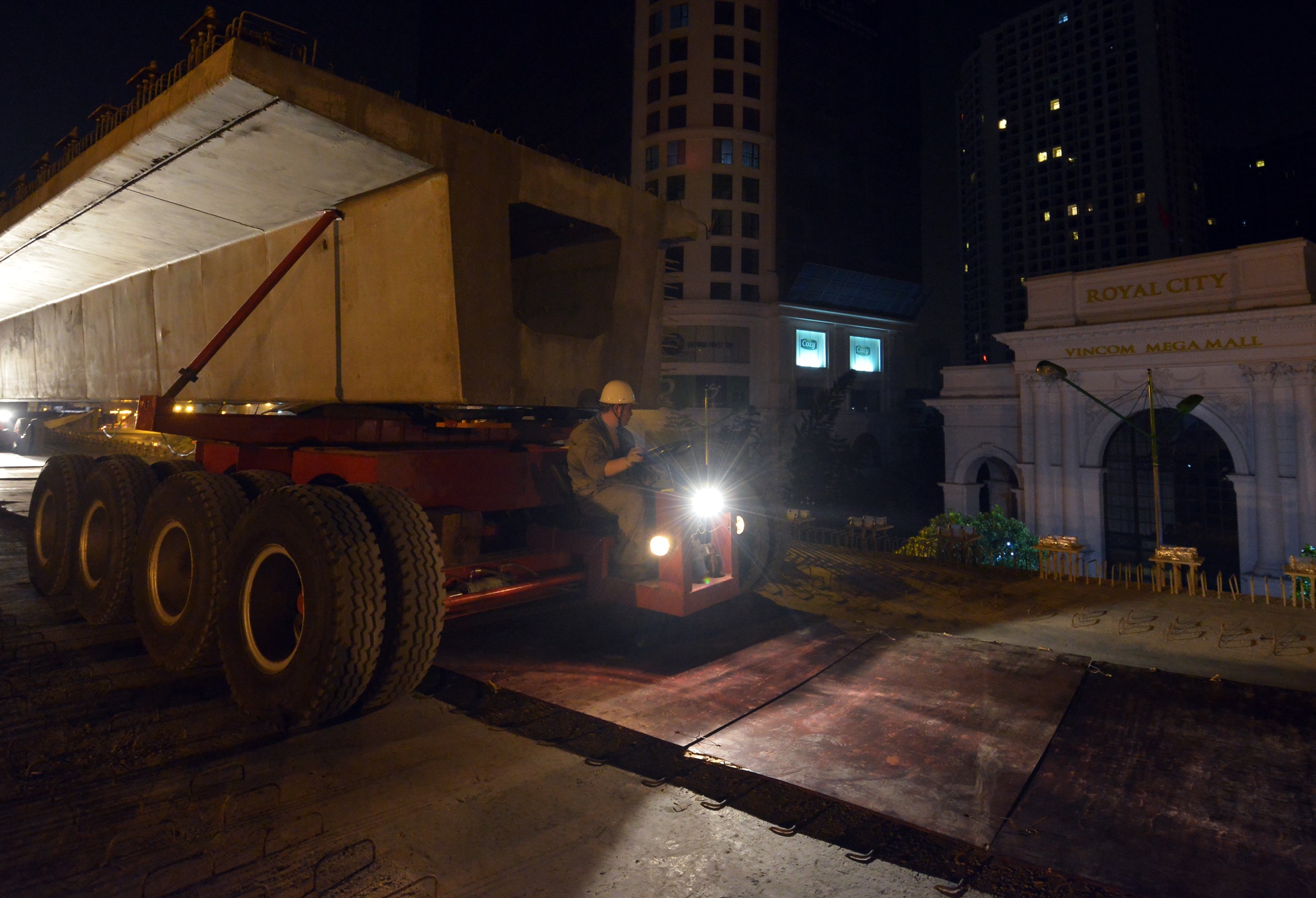 Để thực hiện công việc này, những phiến dầm có trọng lượng hơn 235 tấn sau khi được nâng lên khỏi mặt đất sẽ được 2 xe lao di chuyển theo khúc cong trước cửa khu đô thị Royal City.