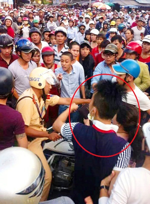 Người có dấu khoanh tròn được xác định là người ngồi sau xe máy khiêu khích CSGT.