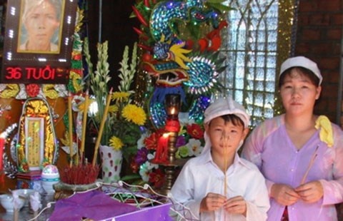 Chị Hoàn và con trai tại đám tang của anh Hơn.