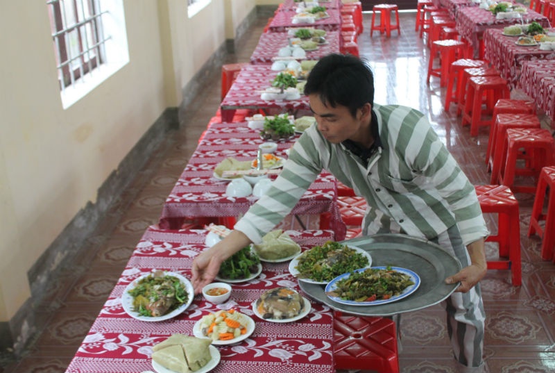 Mâm cơm tất niên trong trại tạm giam vẫn đầy đủ hương vị tết, với bánh chưng, thịt lợn và những món truyền thống. Tất cả đều do bàn tay các phạm nhân chế biến, với nguyên liệu thực phẩm có sẵn trong trại. 