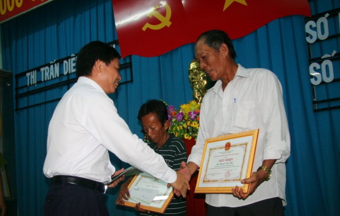 Ông Lương Phan Sảng - phó giám đốc Vietcombank chi nhánh Khánh Hòa (bìa trái) - trao thưởng cho ông Nguyễn Văn Thời (bìa phải) và ông Nguyễn Bảo Quốc.
