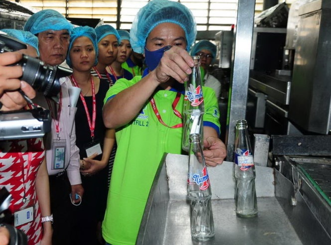 Nhân viên công ty Tân Hiệp Phát trình diễn quy trình phát hiện vật thể lạ trong chai nước trong lần thanh tra của thanh tra Sở Y tế Bình Dương.