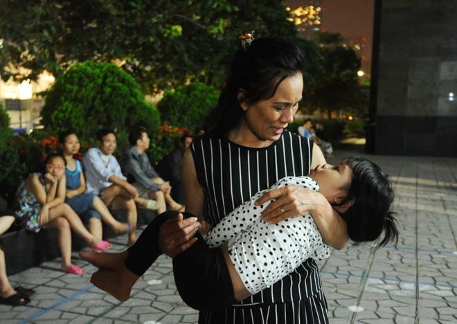 23h50, người dân vẫn chưa thể về nhà. Nhiều trẻ nhỏ mệt mỏi ngủ trên tay người lớn. Tới 00h30, nhiều người dân đã di chuyển sang nhà người thân tạm trú. Một số khác vẫn đang ở tòa nhà kế bên chờn lực lượng chức năng hoàn tất công tác khám nghiệm để về nhà. 