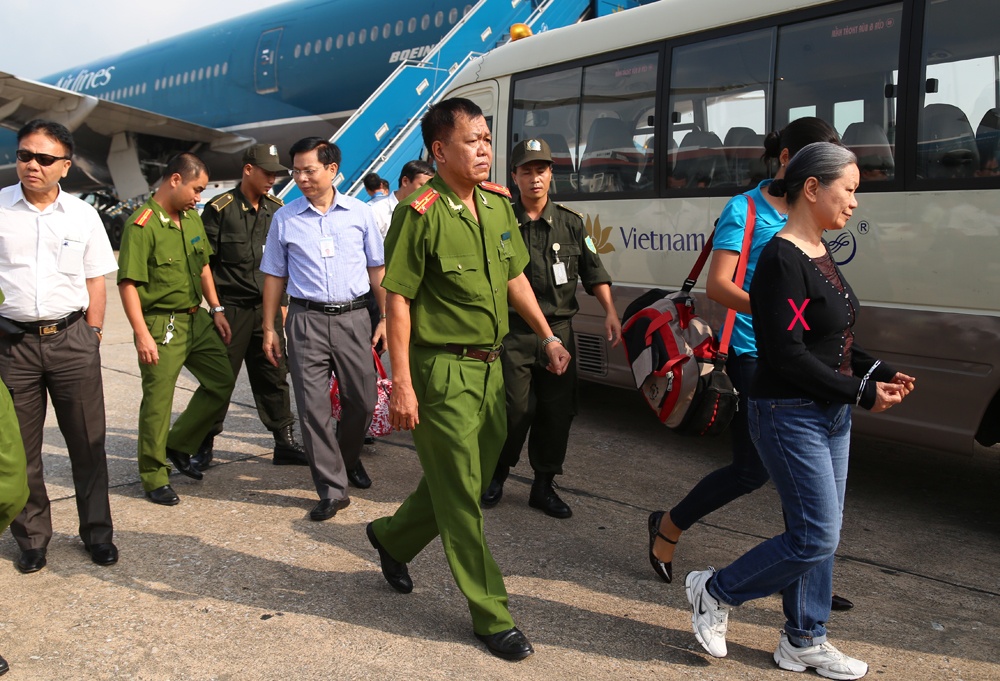 Cục Cảnh sát truy nã Bộ Công an bắt giữ, dẫn giải một nữ tội phạm (X).