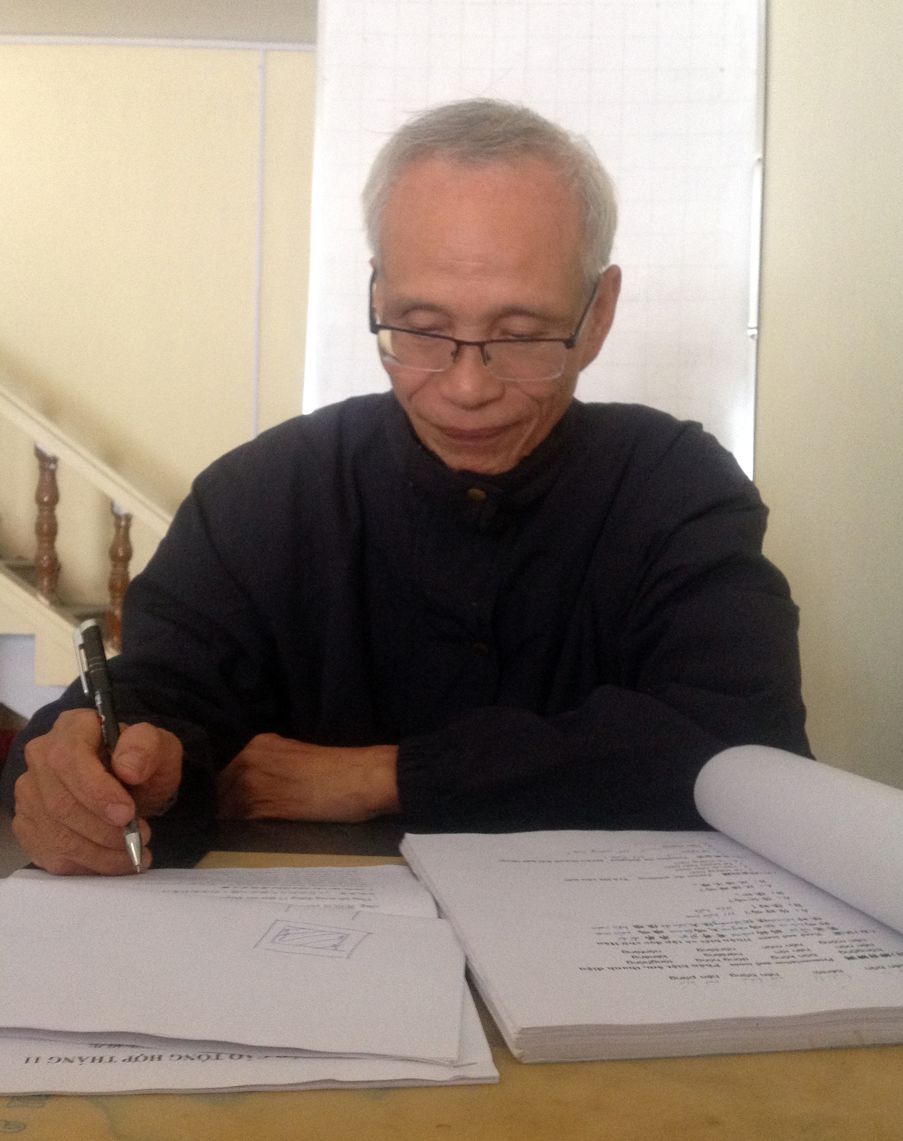 Ông Phan Quốc Bảo đang dịch một tài liệu tiếng Trung.