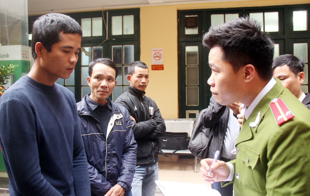 Cảnh sát xét hỏi cò mồi bị tạm giữ. Ảnh: Việt Đức.