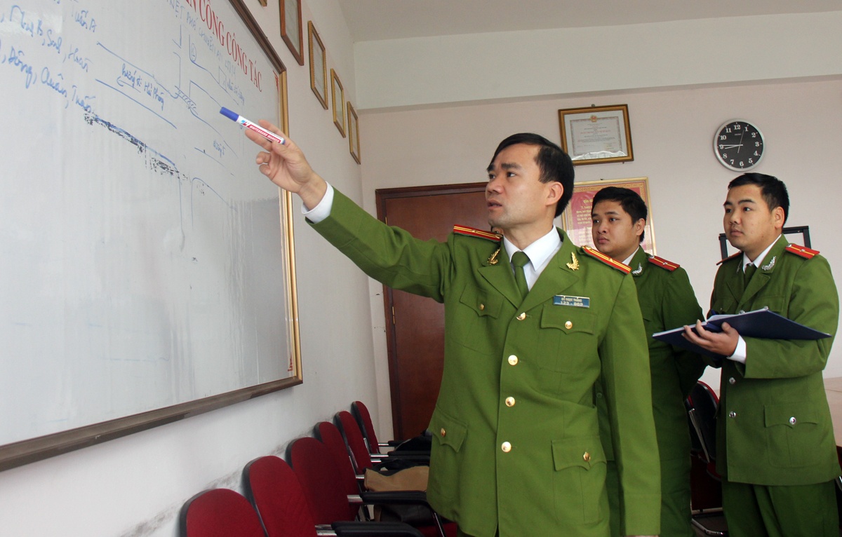 Thiếu tá Thắng phổ biến sơ đồ phá án cho cán bộ trong đơn vị.
