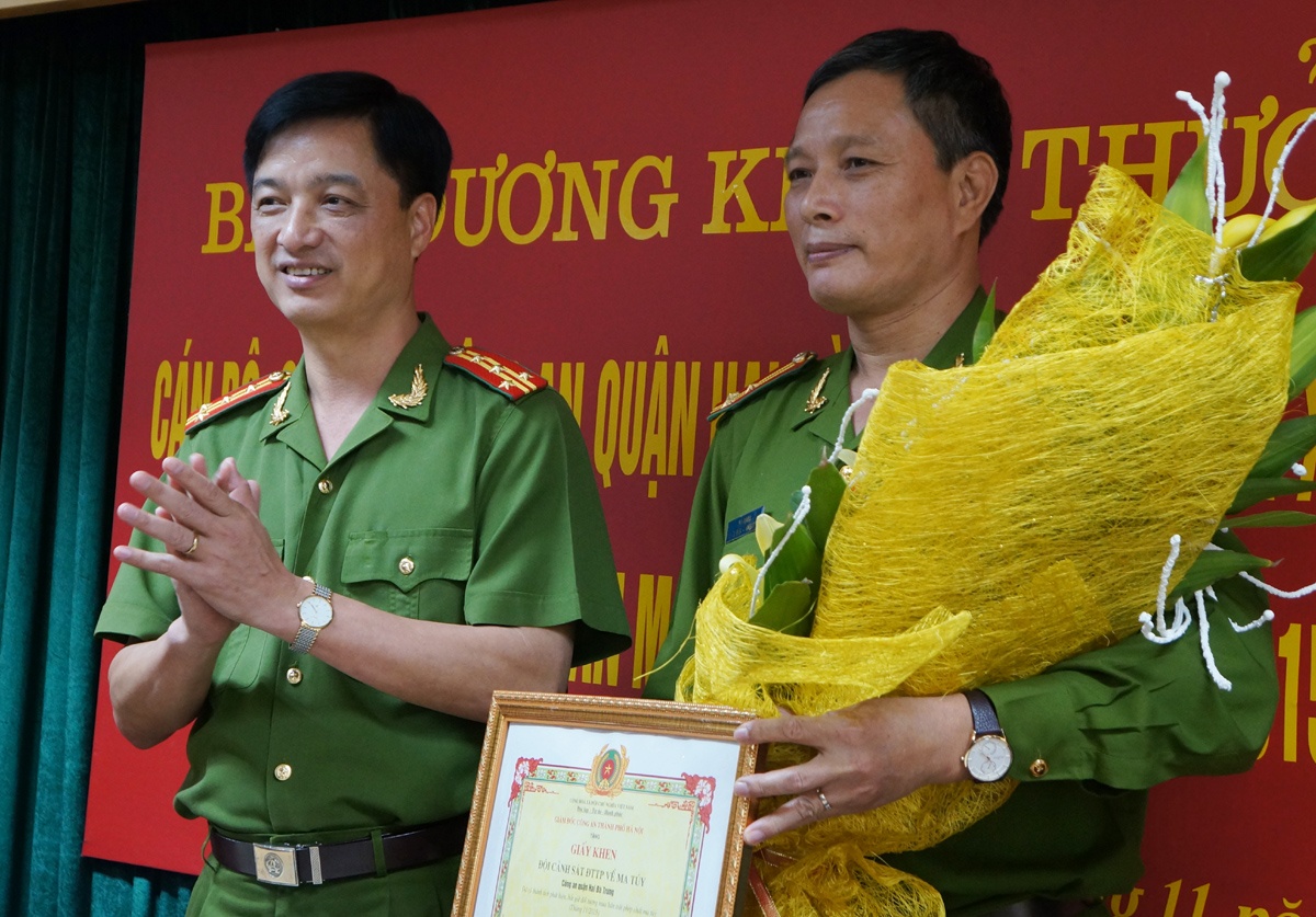 Đại tá Nguyễn Duy Ngọc - Phó giám đốc Công an Hà Nội tăng hoa chúc mừng cá nhân có thành tích xuất sắc. Ảnh: Việt Đức.