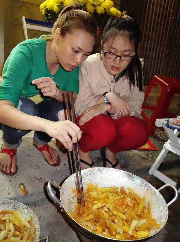 Mỹ Tâm ngồi chăm chú sên mứt gừng, khoai lang cùng cô cháu gái trong dịp Tết vừa qua. 