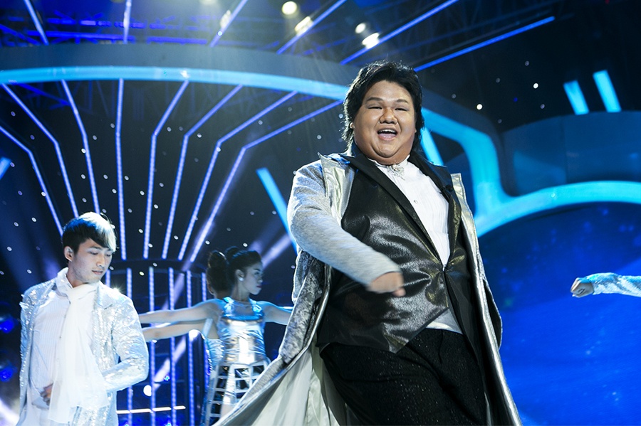 Vương Khang hoá thân thành ca sĩ Trịnh Thiếu Thu với ca khúc Vì một người đi mãi do Việt Quang Huy viết lời Việt. Khó khăn lớn nhất của Vương Khang là hát thì quên lời và hát đúng lời lại quên động tác vũ đạo. Một điều rất đặc biệt là chiếc áo khoác cho nhân vật phải hóa thân mà Vương Khang chuẩn bị tốn hết 8m vải.