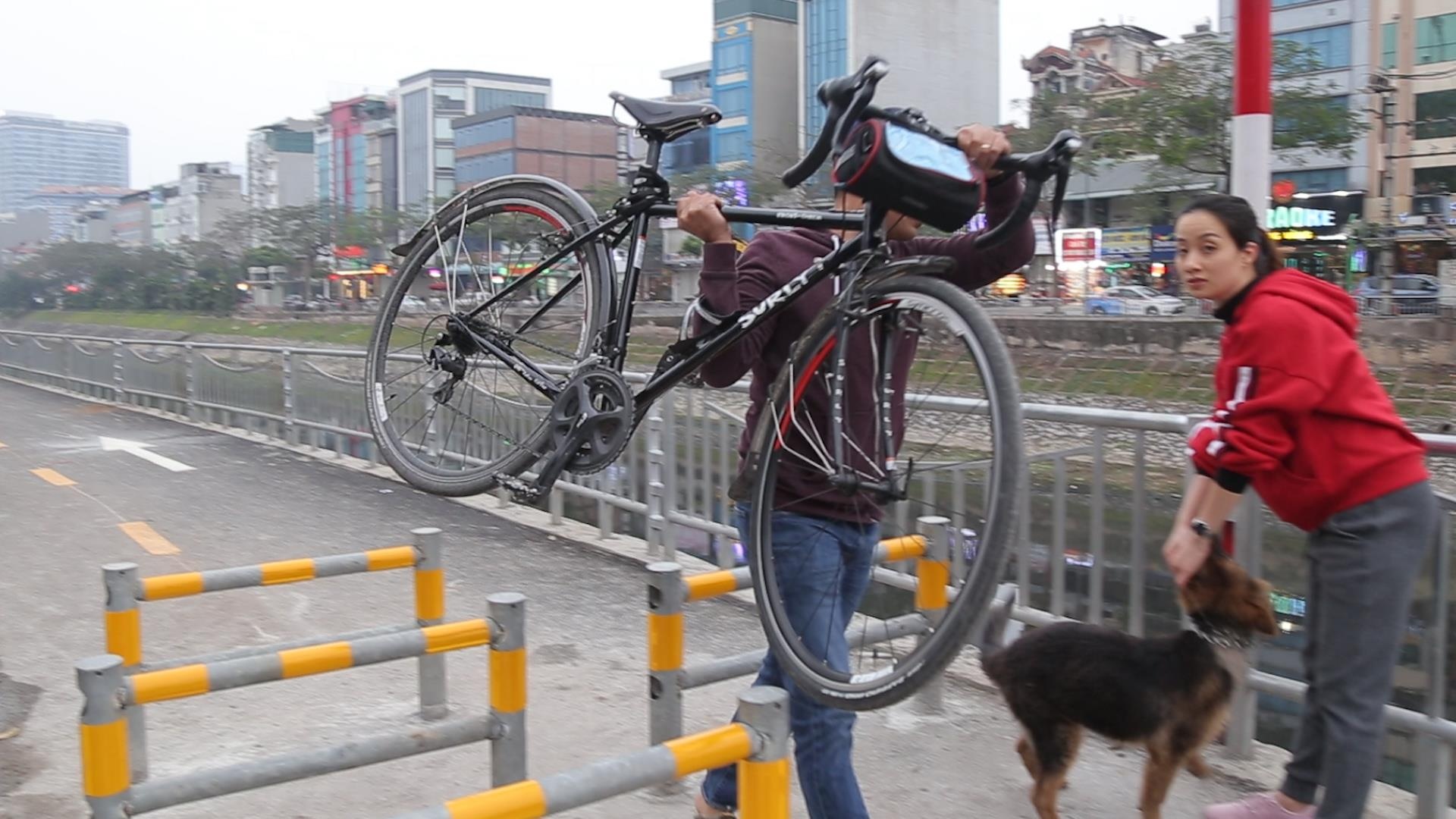 Nguoi dan vac xe dap vuot hang rao tai pho di bo moi cua thu do hinh anh