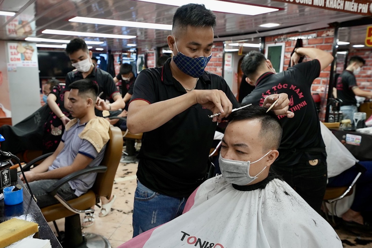 Nguoi dan xep hang o tiem cat toc truoc gio cam hinh anh