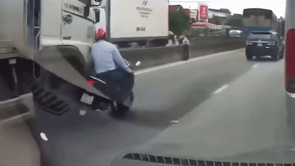 Nguoi dan ong thoat chet trong gang tac duoi banh xe tai hinh anh