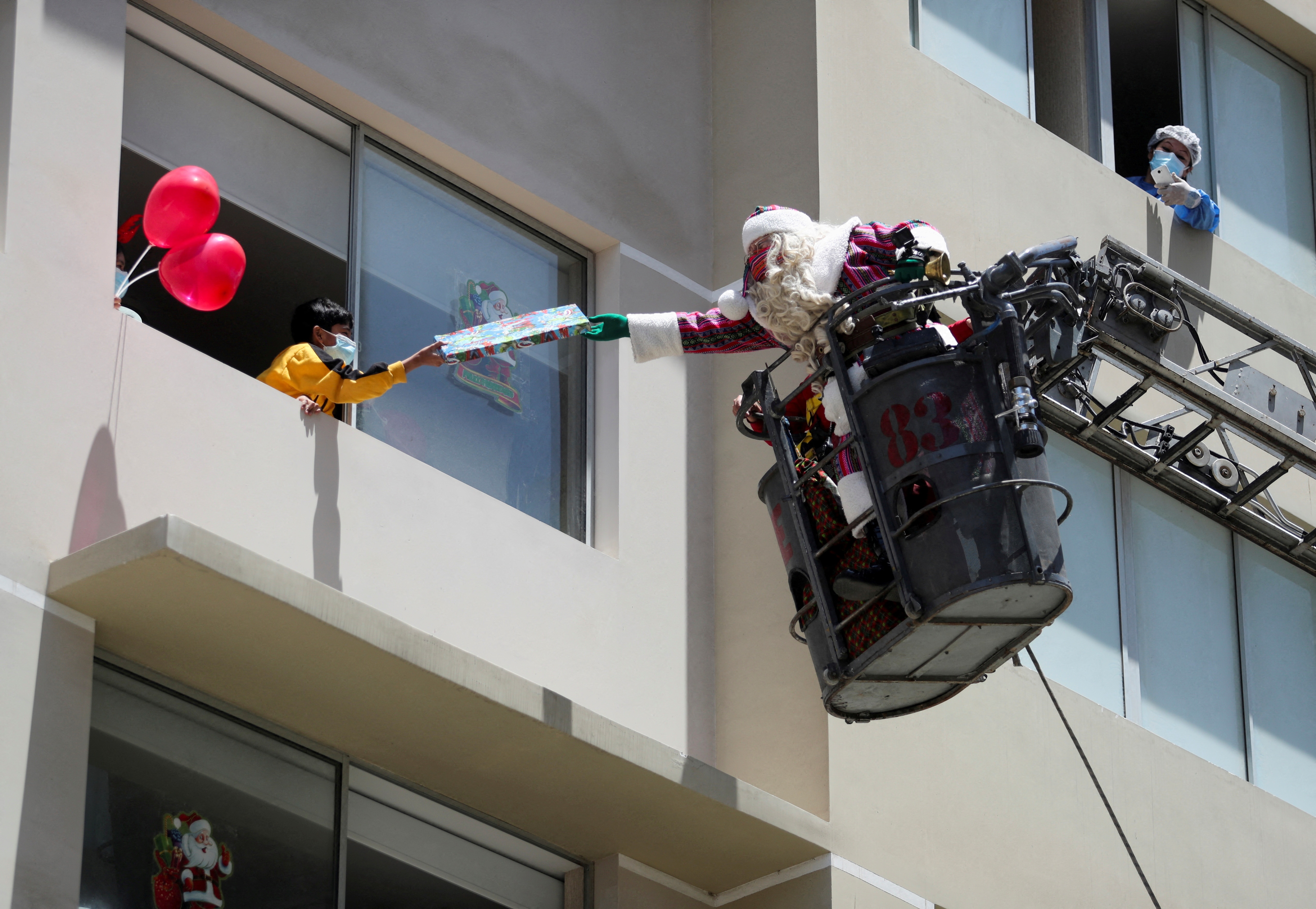 Xe cuu hoa nang ong gia Noel len cao de phat qua cho tre em Peru hinh anh
