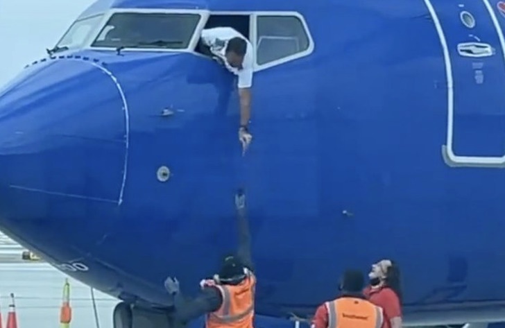 Khoanh khac phi cong nhoai nguoi khoi cua so buong lai may bay hinh anh