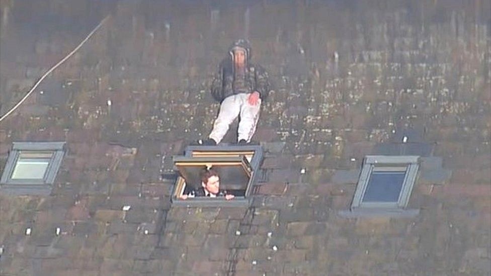 Buc anh gay kinh ngac ve nguoi dan ong tron canh sat tren mai nha hinh anh