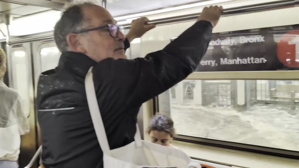 Hanh khach mac ket khi nuoc lu tran vao tau dien ngam o My hinh anh