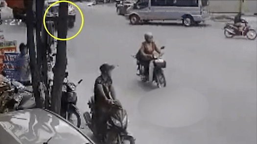 Nguoi phu nu di xe dap dien tu vong duoi gam container hinh anh