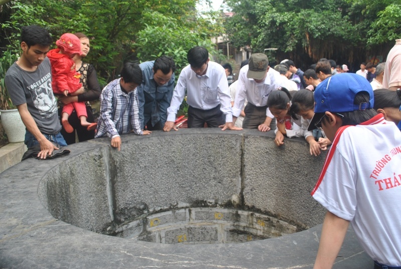 Nhiều du khách vây quanh giếng nuôi cá thần trong đền thờ Tiên La.