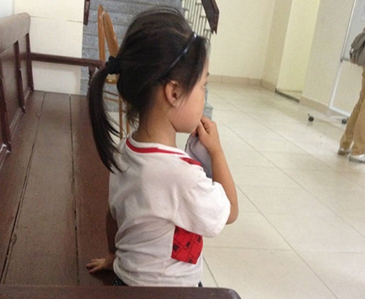 Bé L. đợi trước cửa phòng xử để được gặp bố - Ảnh: T.L.