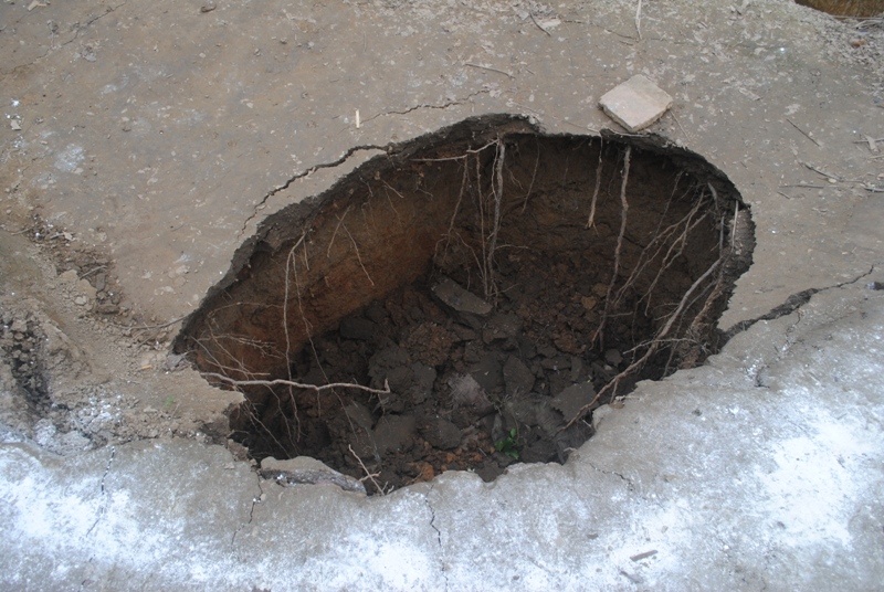 So với miệng hố cũ nằm cách đó vài mét, hố mới này có độ sâu gần 3m, rộng 1,5m và thuộc khu đất bị nứt ban đầu. Ảnh: Duy Cảnh.