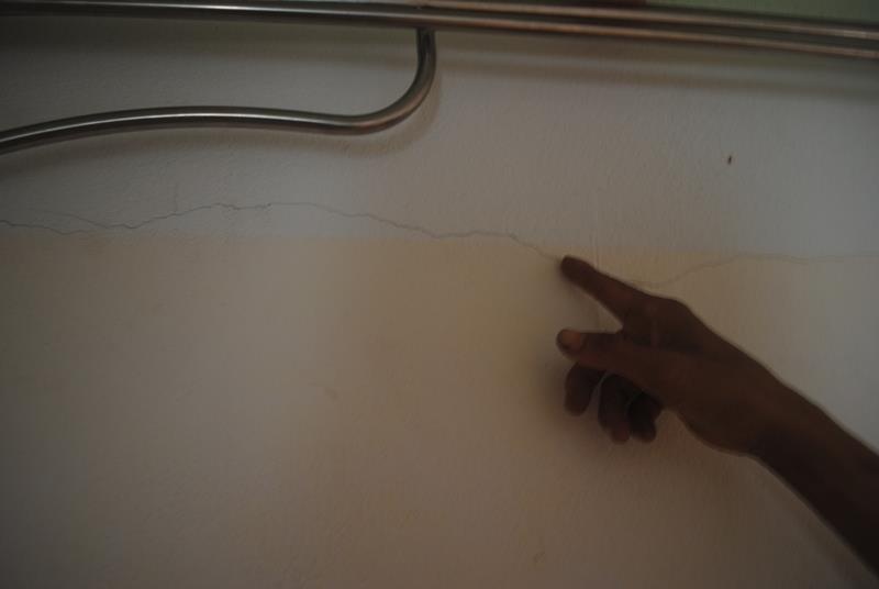 Anh Nghị chỉ tay lên vết tường nứt và tỏ ra lo lắng cuộc sống gia đình. Ảnh: Duy Cảnh.