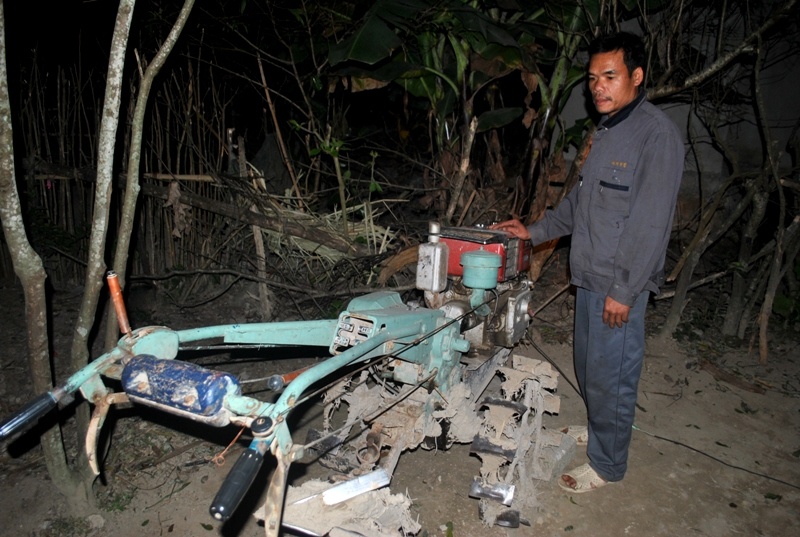 Ông Xuân đứng bên chiếc máy cày - phương tiện phát điện phục vụ bà con trong thôn. Ảnh: Duy Cảnh.