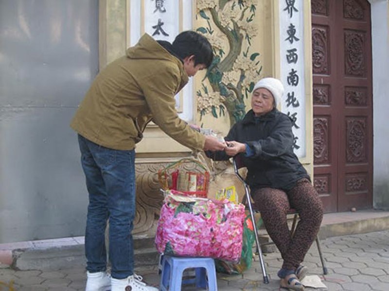 Người phụ nữ đổi tiền trước đền Quán Thánh cho biết nếu khách có nhu cầu đổi tiền lẻ số lượng lớn thì vẫn đáp ứng được Ảnh: NGUYỄN HƯỞNG