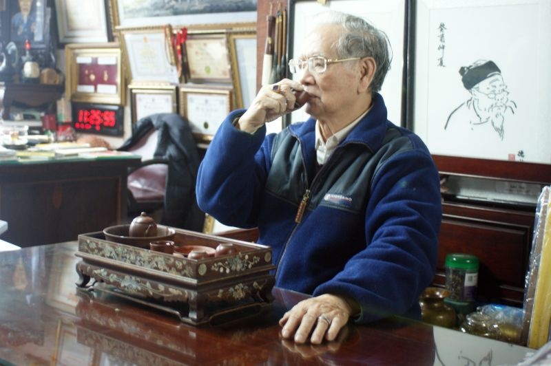 Nghệ nhân Lê Văn Kinh thưởng trà với bộ ấm Mạnh Thần.